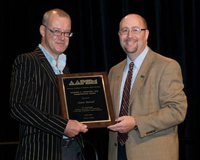 Simon Barthold (left) receives Richard Schuster, DPM Award from Bruce Williams, DPM, during AAPSM Annual Meeting in Toronto. 